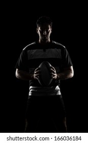 Rugby Player Silhouette In A Black And White Uniform. Black Background