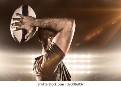 Rugby player throwing ball against spotlight - Powered by Shutterstock