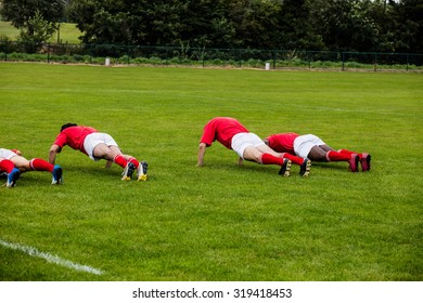 Rugby players doing push ups at the park - Powered by Shutterstock