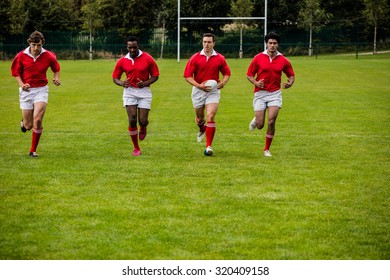 Rugby players jogging with ball at the park - Powered by Shutterstock