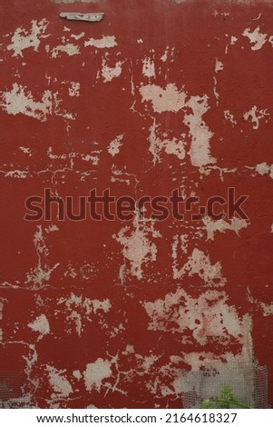 Rugged brown colored painted old wall with paint cracks and dingy spots. Decayed. Background, texture, wallpaper. Brown, burgundy, dark red