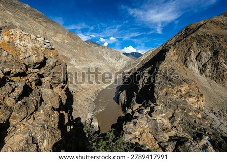 Rugged cliffs and the Nujiang River winding through the Nujiang Grand Canyon near Bangda Town in Tibet under a vivid blue sky.