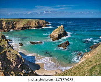 The rugged coastal cliff scenery and pristine turquoise waters around the island of Uyea in Northmavine, Shetland, UK. Taken on a sunny day with a blue sky. - Shutterstock ID 2179776175