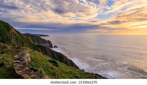 Rugged coastal cliffs by the Devil's Slide trail in California at sunset, and the silky Pacific ocean water from long exposure in the background