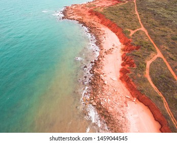 The Rugged Coastline Of Reddell Beach In Broome, Western Australia As Seen From The Air With A Drone. An Outback Road Can Be Seen Running Parallel To The Red Cliffs, Not Far From The Turquoise Water. 