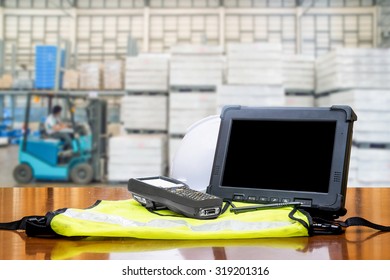 Rugged Computers Tablet And Bluetooth Barcode Scanner In Front Of Modern Warehouse