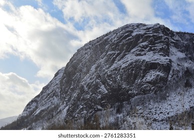 Rugged Granite Cliff Face with Dusting of Snow under Dramatic Winter Sky