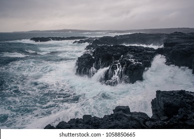 Rugged Icelandic coastline with big  waves hitting the black rocks at overcast evening in south west Iceland. - Powered by Shutterstock