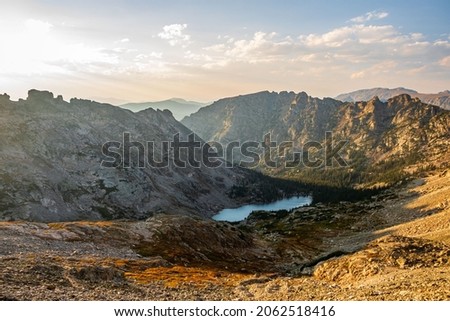 Rugged mountain basin landscape with alpine lake during sunset in the Rocky Mountains, Colorado, USA