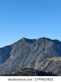 A rugged mountain range under a clear blue sky on a sunny day