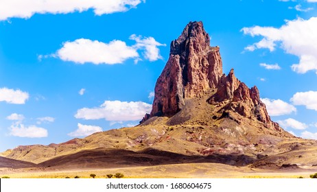 The rugged peaks of El Capitan and Agathla Peak towering over the desert landscape south of Monument Valley along Highway US Route 163 in northern Arizona, United States