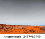 rugged red rock formation in a desert landscape, with a clear sky providing a stark contrast to the vibrant, textured terrain. The scene highlights the natural beauty and geological complexity of the 