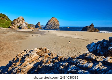 Rugged Rock Formations and Sandy Beach Under Clear Sky at Harris Beach State Park - Powered by Shutterstock