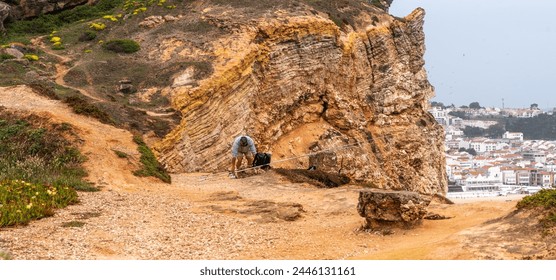 a rugged rocky path, and a fisherman with a long fishing rod against the backdrop of a coastal city and the vast ocean, combining adventure with scenic city views - Powered by Shutterstock