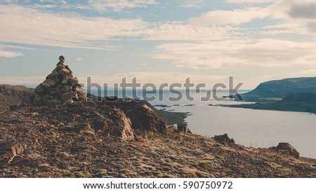 Rugged rocky terrain overlooking distant fjords in Iceland
