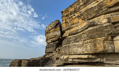 Rugged sandstone cliffs basking under azure skies, embody Tidal Equinox reveries and Whispering Tidewatcher folklore in coastal grandeur