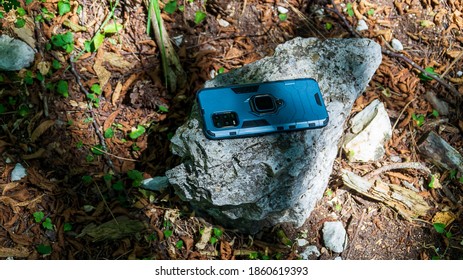 Rugged Smartphone Over The Stone In The Forest In Summer