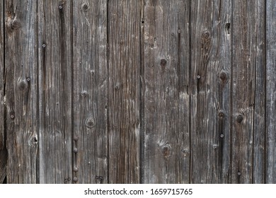 A ruined wood door made with vertical boards, in time this wood became black color.