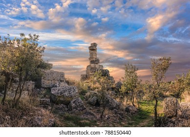 Ruins of an ancient building in a long forgotten city in northwestern Turkey under blue skies with fluffy white clouds during sunset