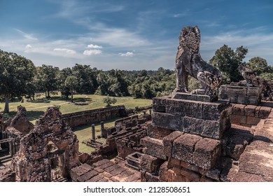 Ruins of ancient Cambodian temple in Angkor complex with trees in background, Siem Reap, Cambodia - Shutterstock ID 2128508651