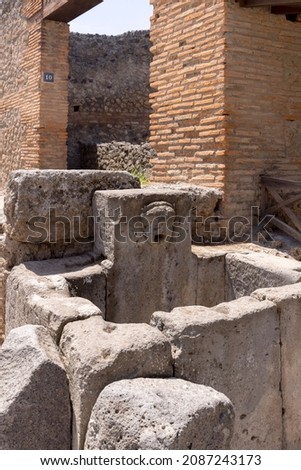 Ruins of an ancient city destroyed by the eruption of the volcano Vesuvius in 79 AD near Naples, Pompeii, Italy. A fountain for public use on one of the streets