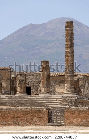 Ruins of an ancient city destroyed by the eruption of the volcano Vesuvius in 79 AD near Naples, Pompeii, Italy. View of the Temple of Jupiter and the mountain Vesuvius 