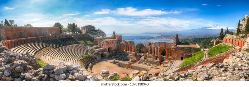 Ruins of ancient Greek theater in Taormina and Etna volcano in the background. Coast of Giardini-Naxos bay, Sicily, Italy, Europe.
