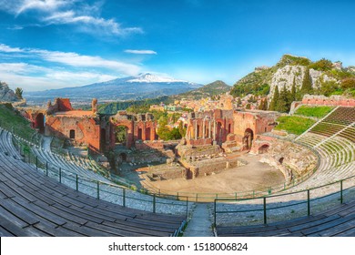 Ruins of ancient Greek theater in Taormina and Etna volcano in the background. Coast of Giardini-Naxos bay, Sicily, Italy, Europe.
