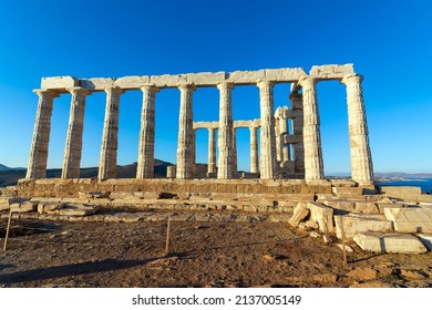 Ruins of an ancient temple of Poseidon at Greece Cape Sounio. Poseidon is the Greek god of the sea. Shot of temple ruins on sunset. Tourist landmark of Attica, Sounion, Greece.