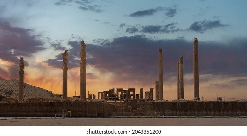 Ruins of Apadana and Tachara Palace behind stairway with bas relief carvings in Persepolis UNESCO World Heritage Site against cloudy sunset sky in Shiraz city of Iran.