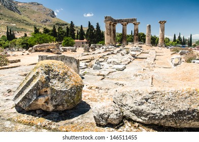 Ruins of Appollo temple with fortress at back in ancient Corinth, Greece 