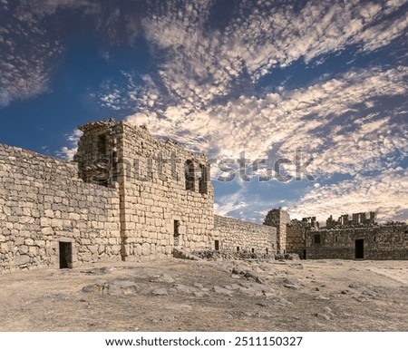 Ruins of Azraq Castle (Qasr al-Azraq) is a crusader castle (300AD),  central-eastern Jordan, 100 km east of Amman, Jordan. Against the background of a beautiful sky with clouds    