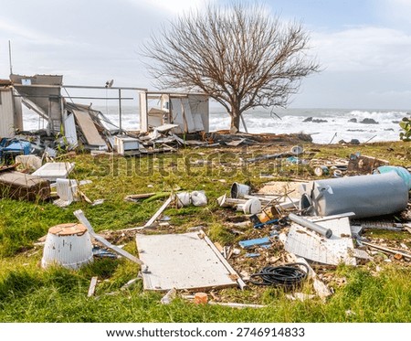 ruins and distructions cousea by a devastating typhoon on a sea coast. wreckage and wastes near sea shore. elimination of the damage and distructions caused by the hurricane to the coast