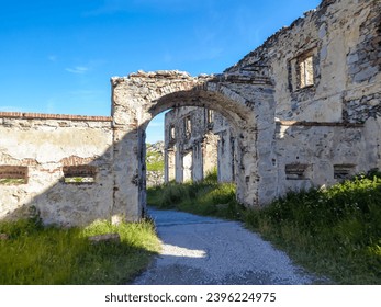 Ruins of a fortress along scenic mtb trail along ancient pathway from the Alps to the sea, through the Italian regions of Piemonte and Liguria, and France. Looking mountain ranges, lush green pastures