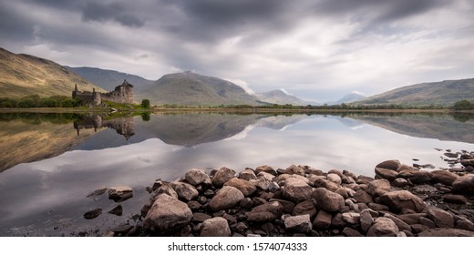 The ruins of Kilchurn Castle, home of the Clan Campbells of Glenorchy, and the mountains of Argyll are reflected in the calm waters of Loch Awe in the West Highlands of Scotland. - Shutterstock ID 1574074333
