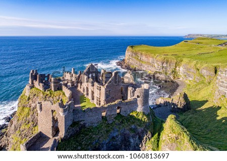 Ruins of medieval Dunluce Castle, cliffs, bays and peninsulas. Northern coast of County Antrim, Northern Ireland, UK.  Aerial view.