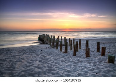 Ruins of the old Naples Pier at sunset on the ocean on the beach of Naples, Florida