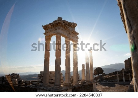 Ruins of the Temple of Trajan the ancient site of Pergamum (Pergamon). Izmir, Turkey. Ancient city columns with the sun in the background.
