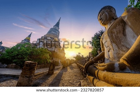 Ruins of Wat Yai Chai Mongkol with statues of Buddha in Ayuthaya historical park. UNESCO Site.