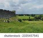 Ruins of a well preserved medieval stone castle on rocky hill with view on the surrounding grassland on a partly cloudy day