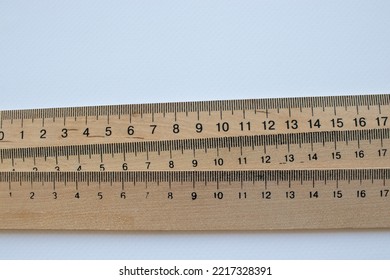 Ruler on a white background. Stack of wooden rulers on white table. Top view, copy space