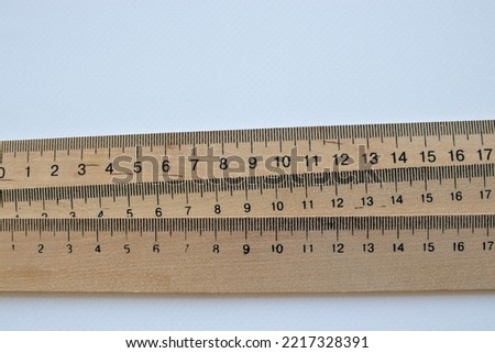 Ruler on a white background. Stack of wooden rulers on white table. Top view, copy space