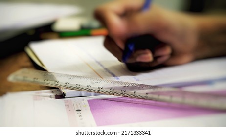 A ruler is placed on a book with a picture of a boy's hands doing homework. - Powered by Shutterstock