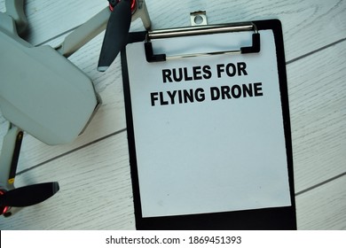 Rules For Flying Drone write on a paperwork isolated on Wooden Table.