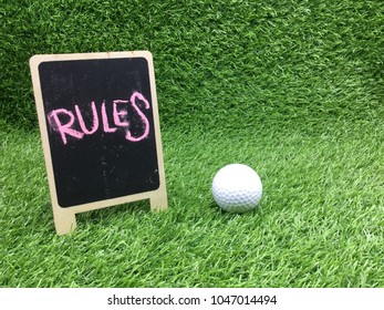 Rules Of Golf With Golf Ball And Chalk Board On Green Grass