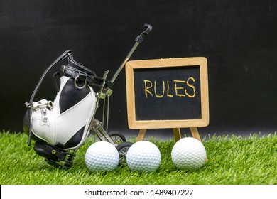 Rules Of Golf With Golf Ball Are On Green Grass With Sign 