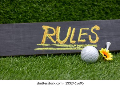 Rules Of Golf With Golf Ball And Yellow Flower On Green Grass