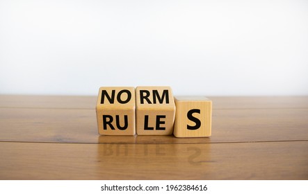 Rules or norms symbol. Turned cubes and changed the word 'norms' to 'rules'. Beautiful wooden table, white background, copy space. Business and rules or norms concept.