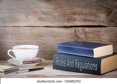 Rules And Regulations. Stack Of Books On Wooden Desk