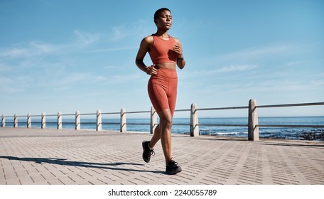 Run, black woman and beach for workout, exercise and training for wellness, health and cardio. African American female, runner and athlete practice, fitness and endurance for marathon, race and ocean - Powered by Shutterstock